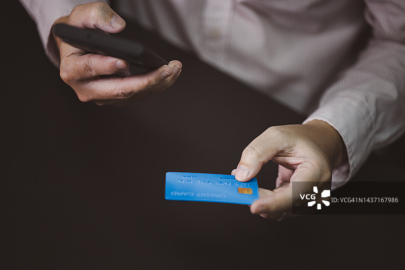 手持信用卡和笔记本电脑的特写图片素材