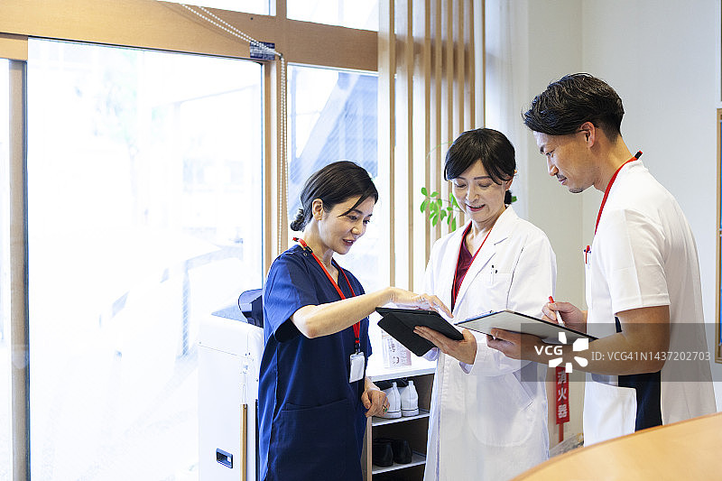 女医生在医院大厅与医疗团队讨论图片素材