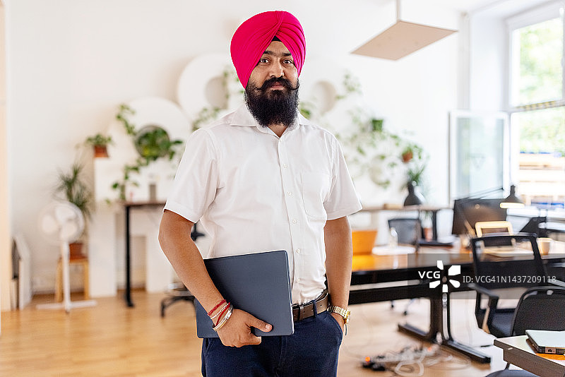 在共享办公室内戴头巾的锡克族商人肖像图片素材