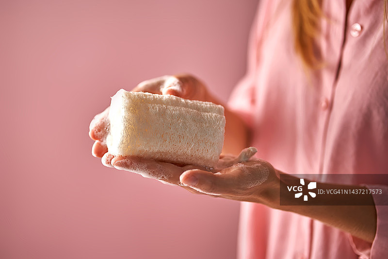 手持天然丝瓜海绵的粉衣女孩图片素材