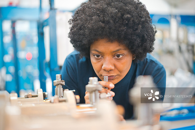 拥有非洲发型的女工程师在工业界检查机械图片素材