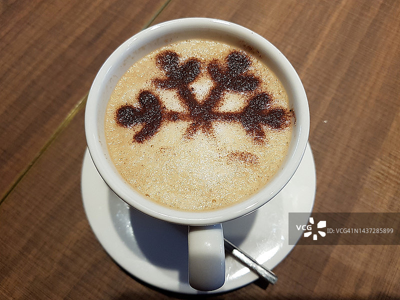 一杯带有巧克力叶子装饰的拿铁咖啡，特写图片素材