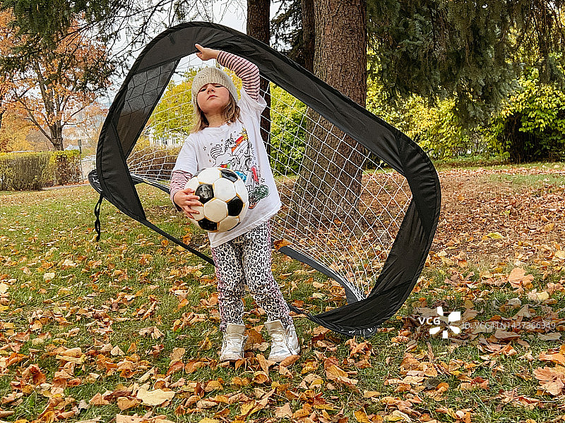 在公园里拿着足球和小型球门的女孩图片素材