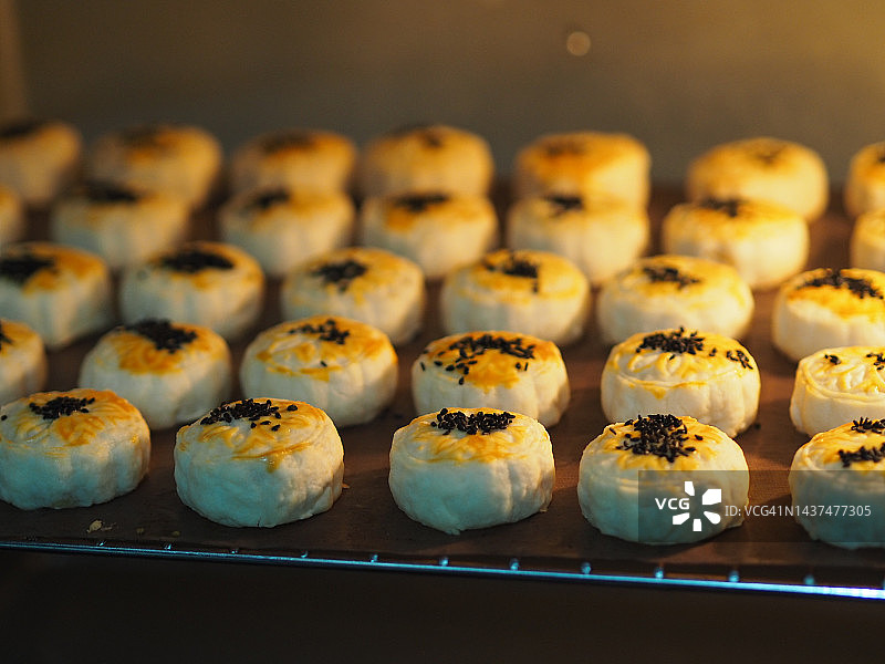 月饼、中式酥皮糕点、咸蛋黄豆饼、泰式绿豆糕和黑芝麻鸡蛋蛋糕，置于不锈钢烤架上图片素材