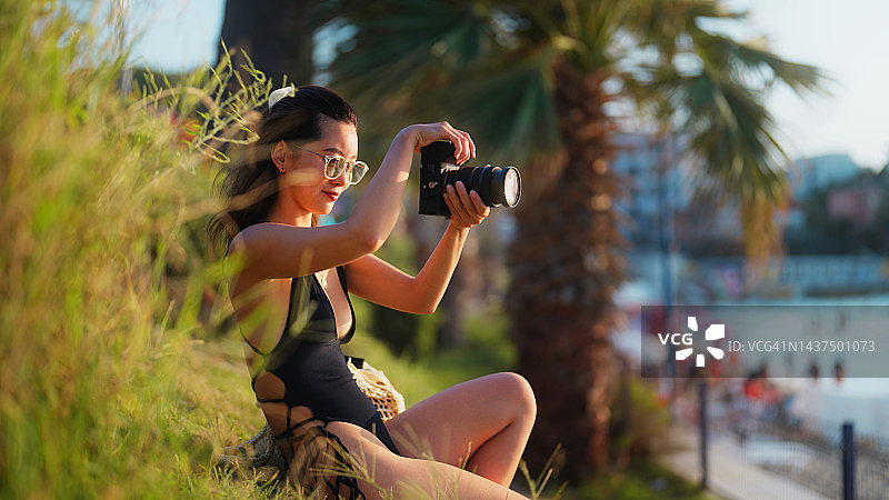 在海边拍摄照片和视频的年轻女游客图片素材