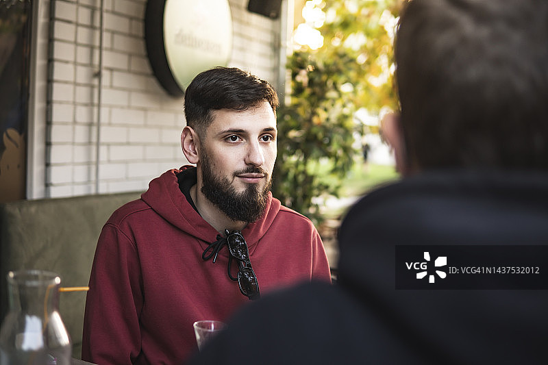 坐在咖啡馆的桌子旁聊天的白人男子们图片素材