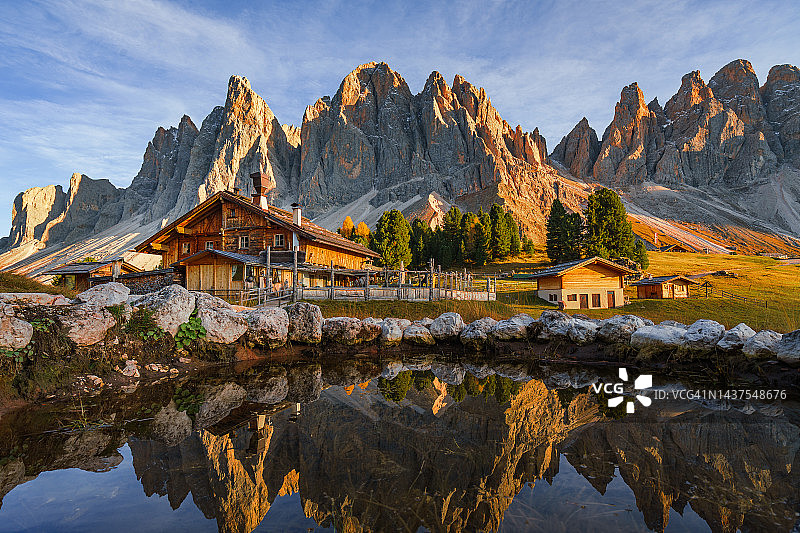 阿尔卑斯山小屋前盖斯勒峰的完美反光图片素材