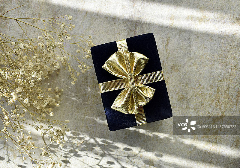 带有金色蝴蝶结的黑色礼品盒图片素材