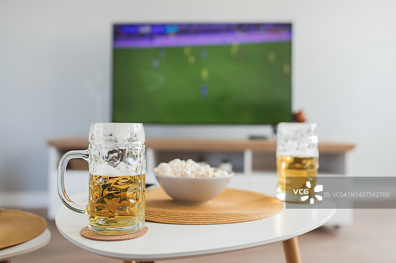 在电视上看体育冠军赛，喝啤酒图片素材