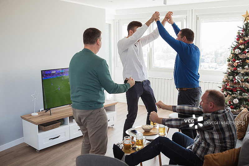 狂喜的男人们庆祝他们最喜欢的球队进球图片素材