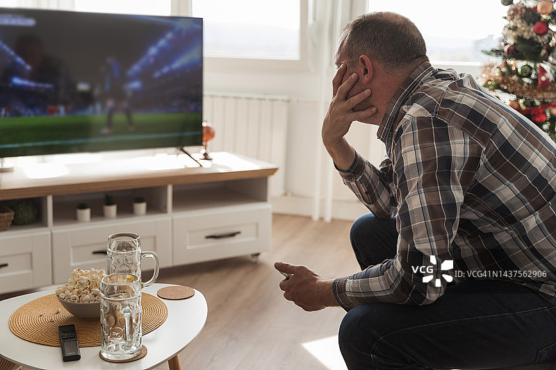 男子在家看电视足球赛图片素材