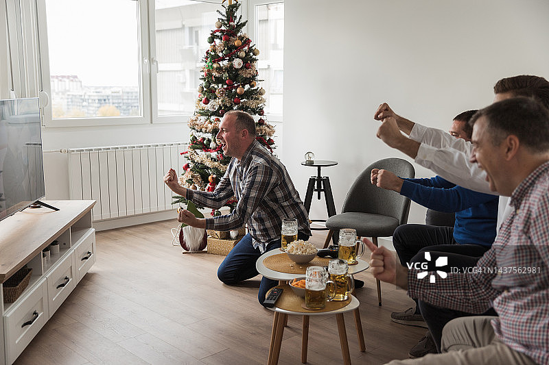 男人们对着电视上的篮球比赛欢呼雀跃图片素材