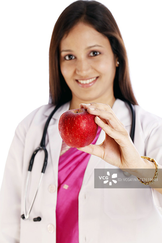 快乐的女医生拿着红苹果图片素材