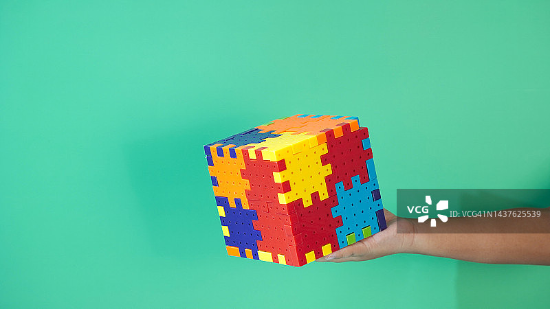 孩子们的手拿着已完成的拼图，留有文案空间图片素材