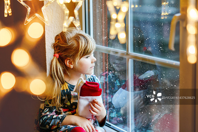 小女孩，圣诞袜礼物，窗边节日庆祝图片素材