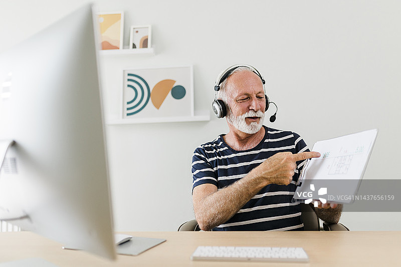 老年男人在呼叫中心工作时使用电脑的照片图片素材