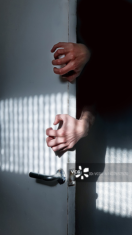 从白色门后阴影中伸出人手的恐怖画面图片素材