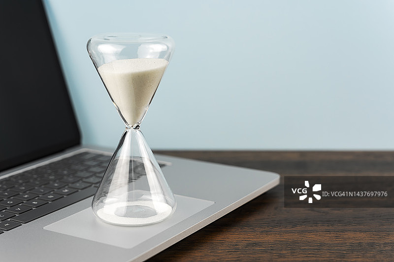 笔记本电脑上的沙漏计时器图片素材