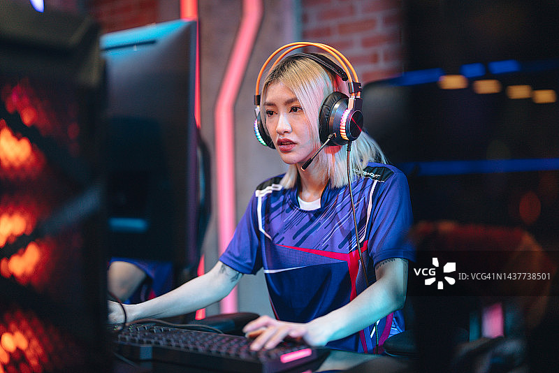年轻的亚洲女性职业玩家在竞技场赢得比赛图片素材