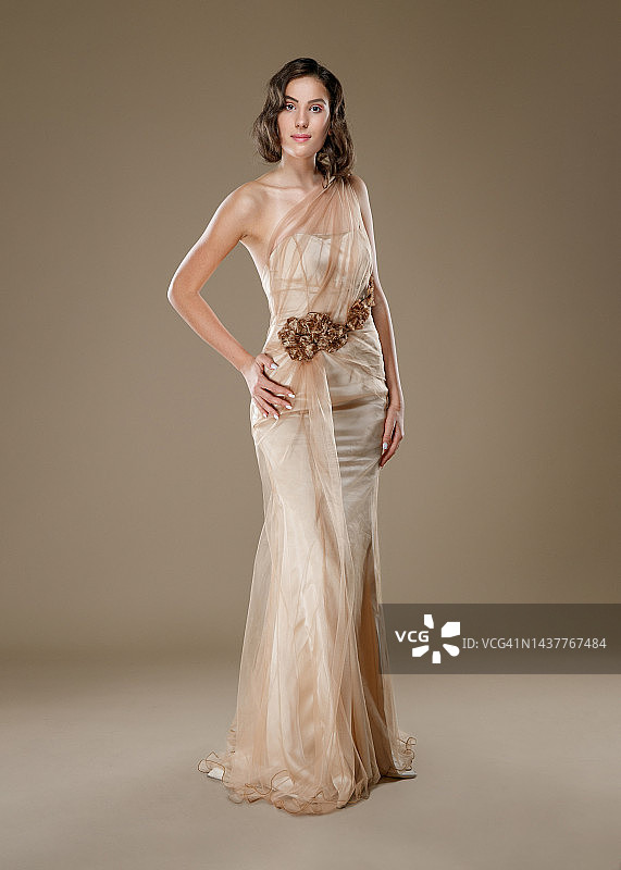 年轻女人香槟色无袖长裙叉腰看向镜头图片素材