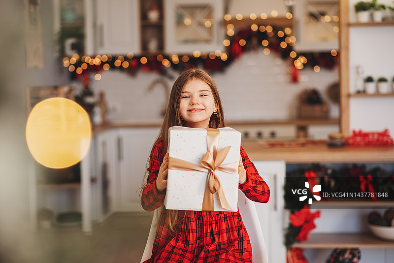 小女孩拿着圣诞礼物，无法辨认是谁图片素材