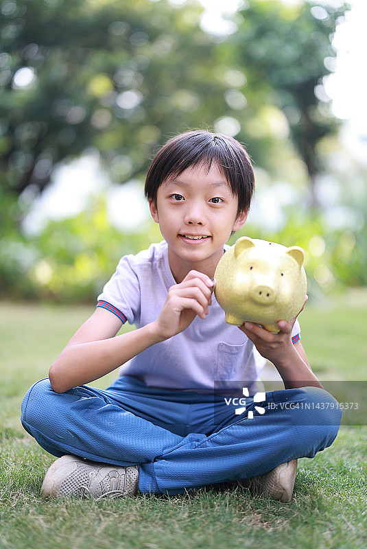 男孩拿着小猪存钱罐图片素材