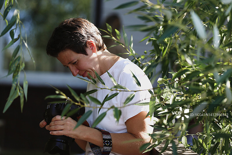年轻女摄影师在户外拍摄新闻照片图片素材