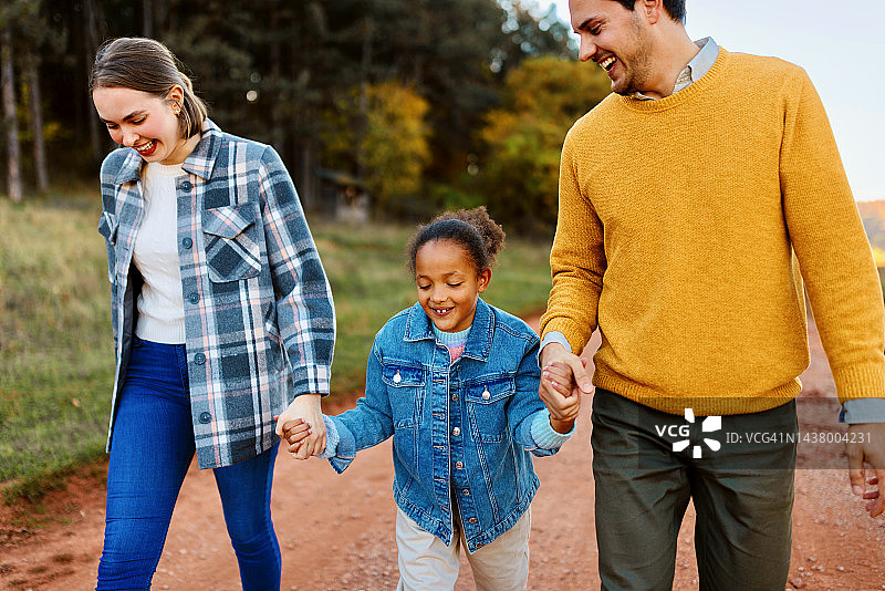 养父母和女儿共度阳光明媚的秋日图片素材
