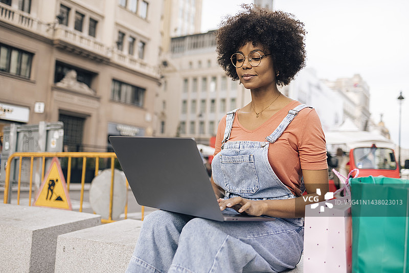 年轻的非裔女性在度假时在街上进行视频通话图片素材