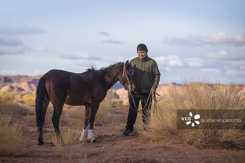 纪念碑谷中骑马的纳瓦霍男孩图片素材