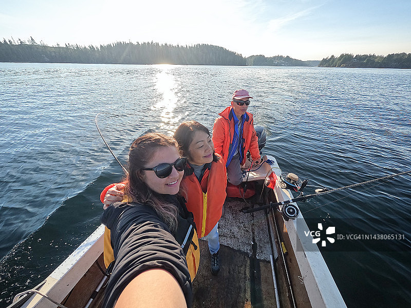多种族多代家庭在船上享受海上钓鱼图片素材