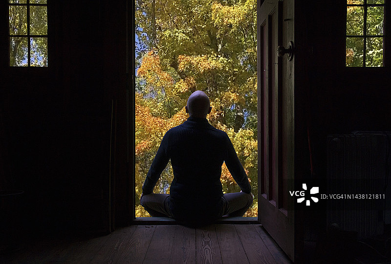 男人在他的房子前冥想图片素材
