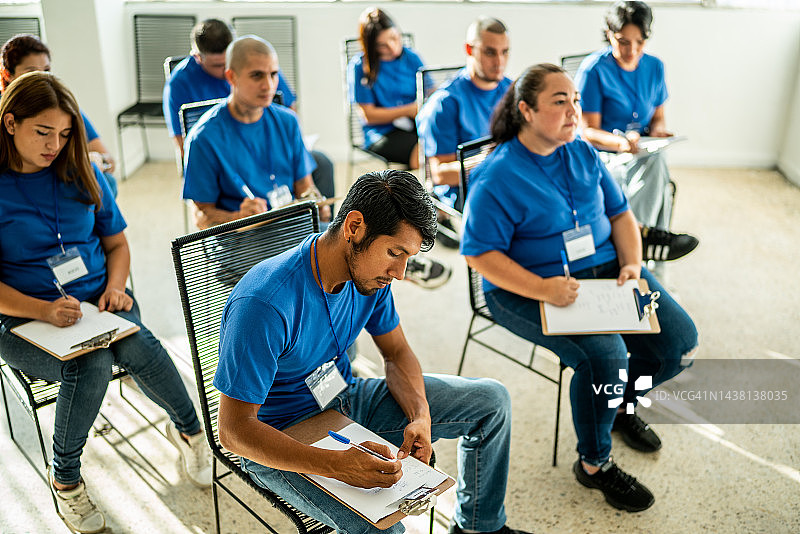 志愿者在社区中心会议上用剪贴板记录图片素材