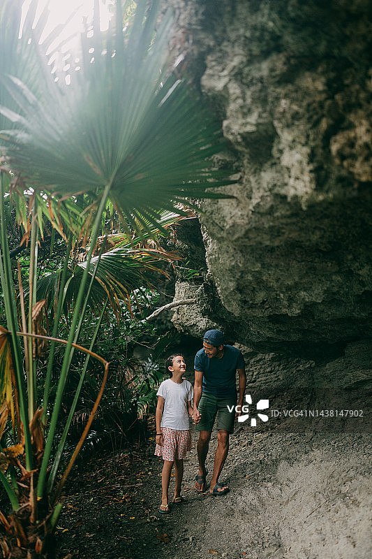 父亲和年幼的女儿在洞穴中行走图片素材