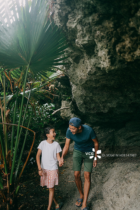 父亲和年幼的女儿在洞穴中行走图片素材
