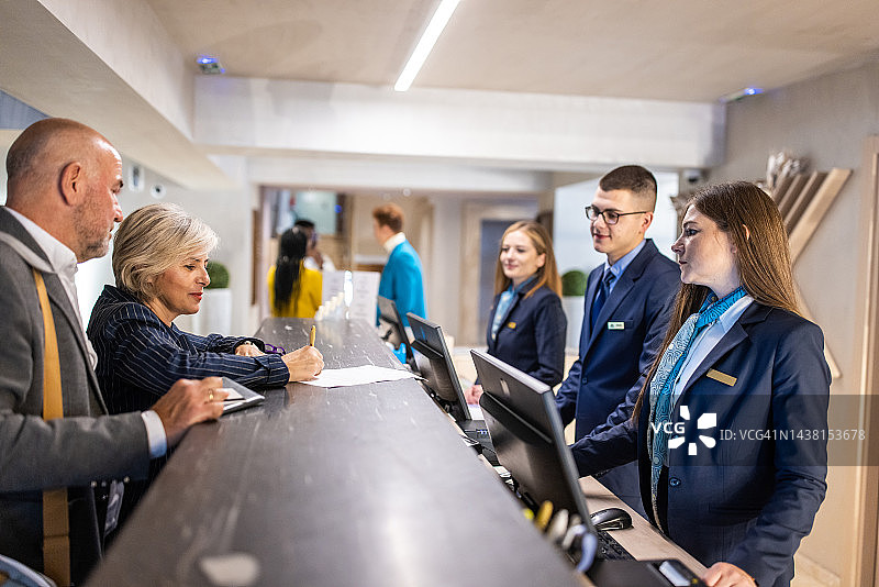 女商人于酒店前台办理入住图片素材