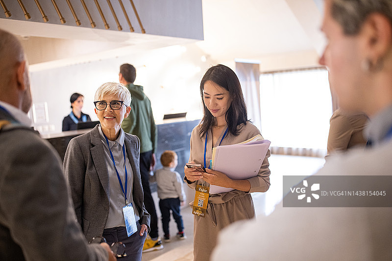 商务会议的与会者在酒店大堂社交，等待会议开始图片素材
