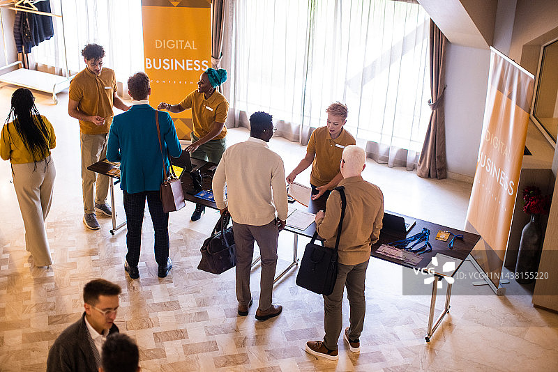 商务会议参与者在豪华酒店大堂注册参会图片素材
