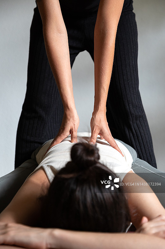 按摩师为女人做泰式背部按摩特写（竖版）图片素材
