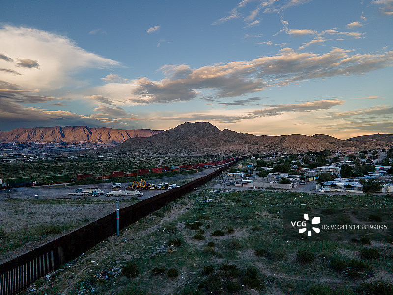 美国德克萨斯州埃尔帕索与墨西哥奇瓦瓦州华雷斯之间边境墙的夜间云景无人机视角（安那普拉港）图片素材