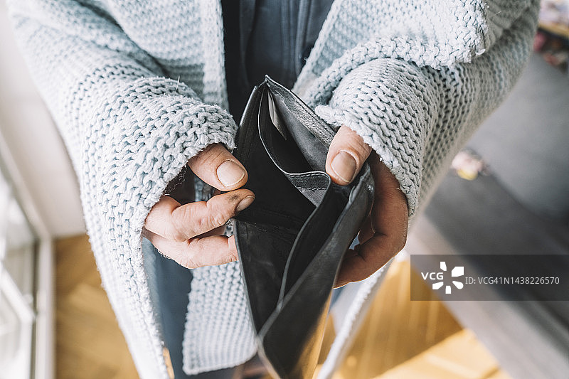 裹着毯子拿着空钱包的男人的手图片素材