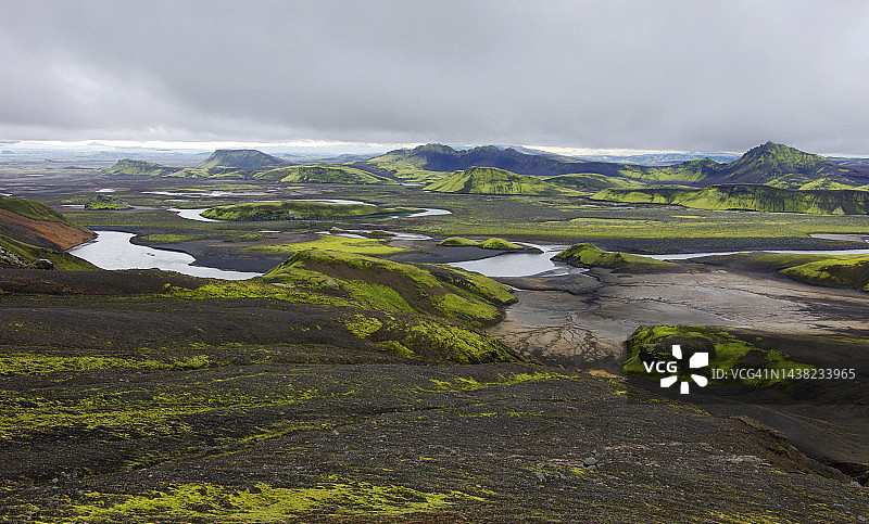 斯卡夫塔河和偏远的朗吉斯约湖之间的黑色沙滩、绿色苔藓和散落野花的火星地貌景色，一条徒步小径穿过图片素材