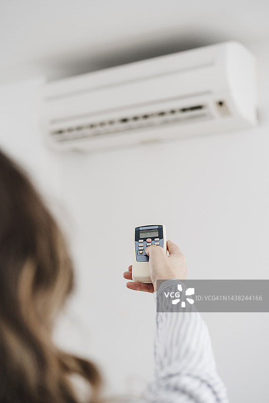 商务女性打开办公室的空调图片素材