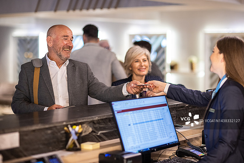 商务人士在前台办理酒店入住图片素材