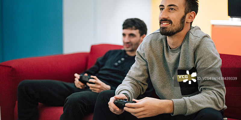 在室内用游戏机玩电子游戏的男性肖像图片素材