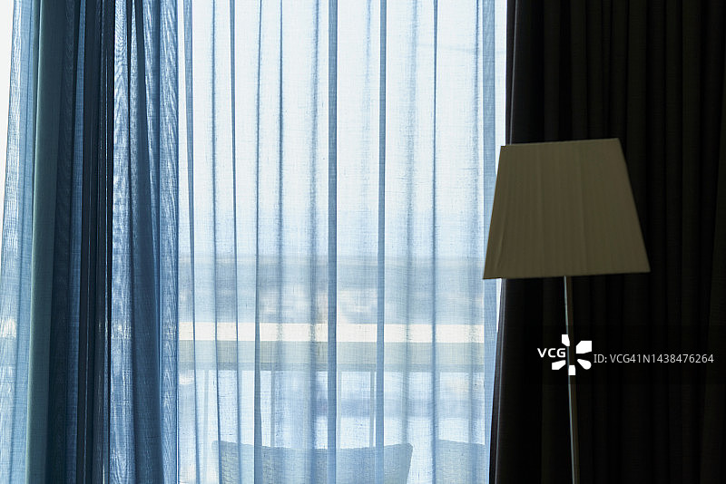 浅蓝色窗帘和米色落地灯图片素材
