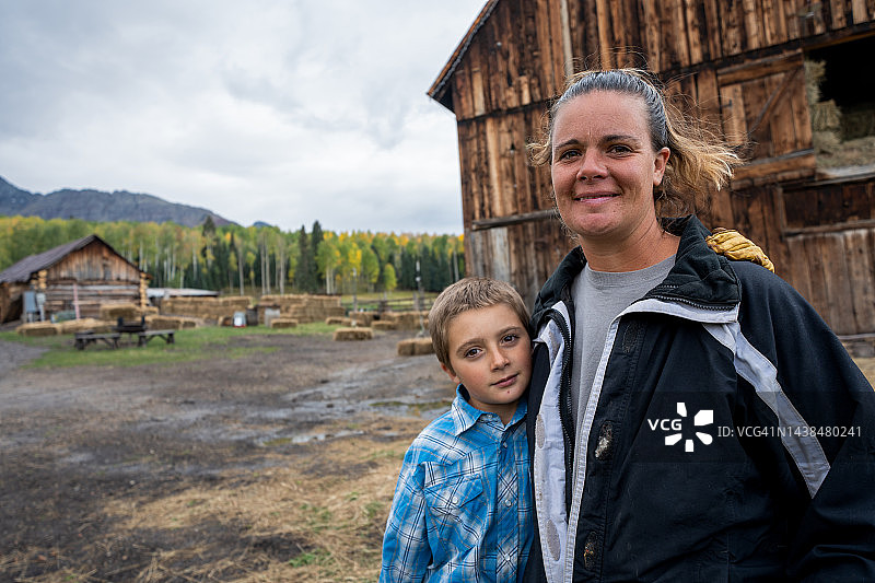 年轻乡村母子秋季谷仓前肖像图片素材