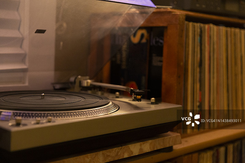 现代家庭办公室中的唱片播放机特写，背景中有大量唱片图片素材