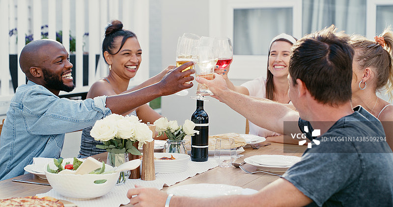 午餐：朋友们在户外露台举杯庆祝图片素材