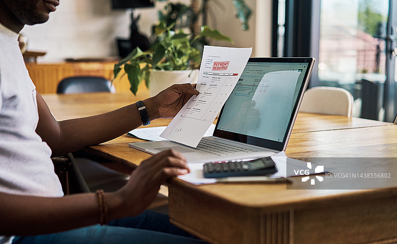 公司商人使用笔记本电脑处理财务文件图片素材